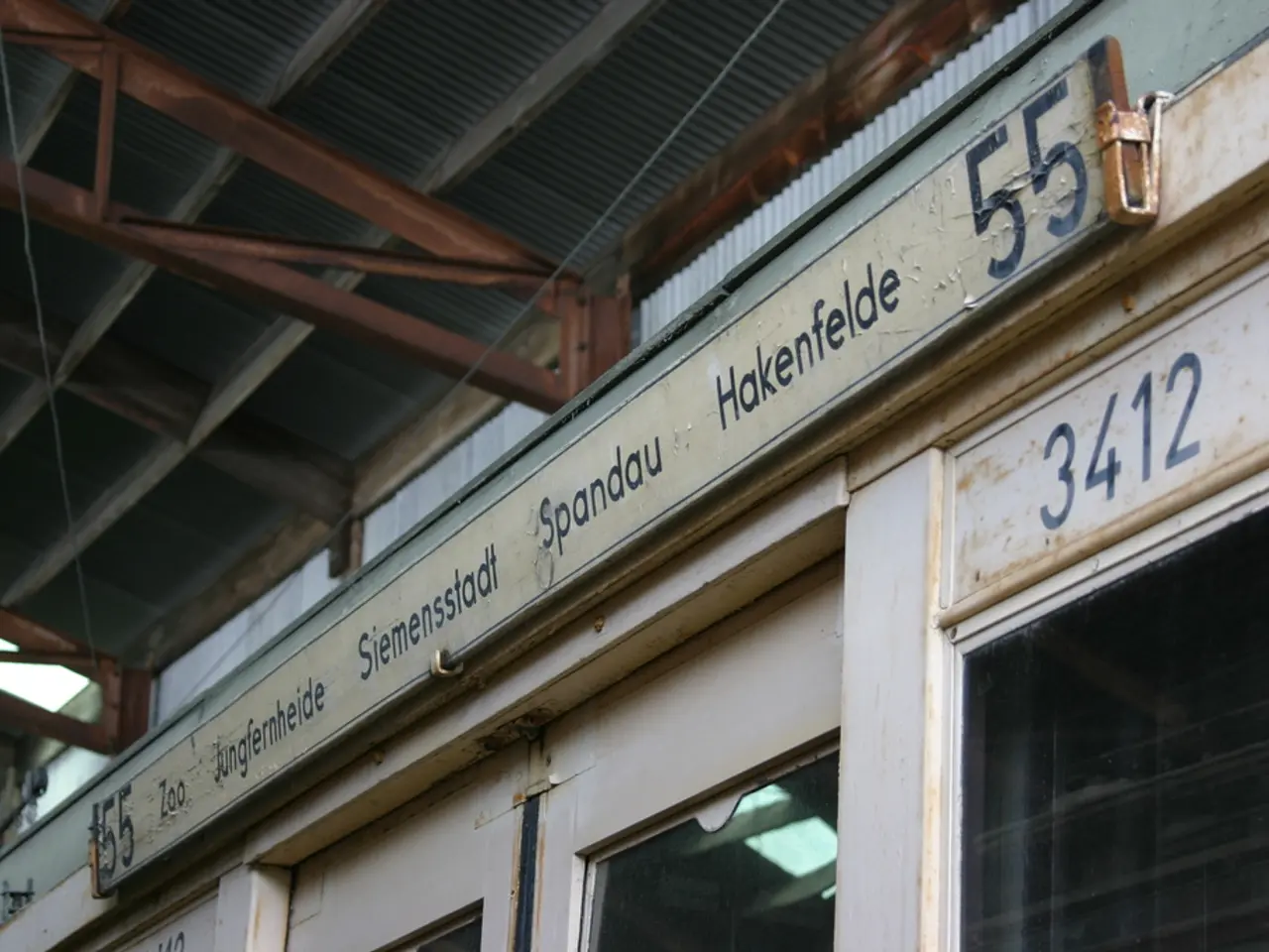 In this picture there is a small shop with naming board. Above there is a metal frame shed.