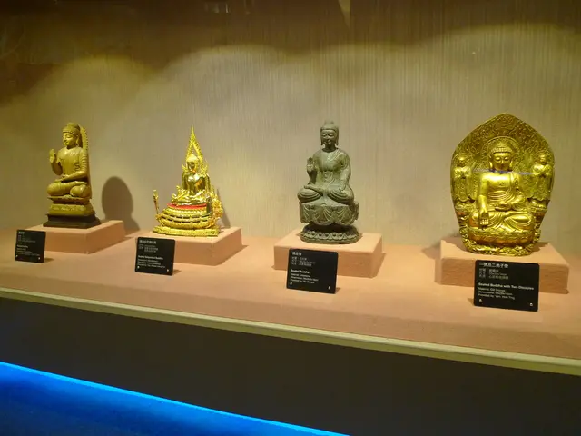 In this image there are four idols one beside the other. In front of them there are boards on which...