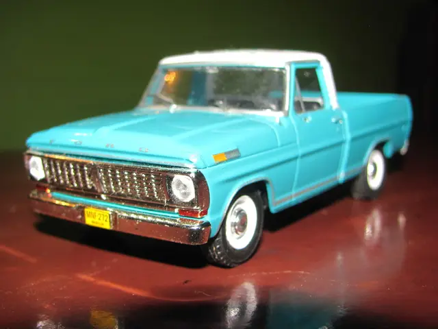 In this image there is a small blue color toy car on the red color floor.