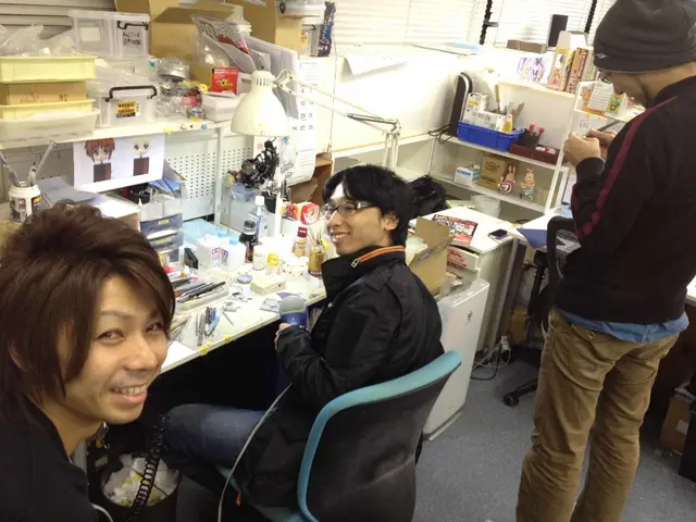 In this image we can see people sitting on the chairs and standing on the floor. In the background...