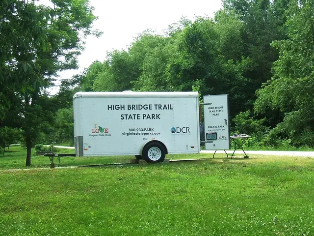 This picture is clicked outside. In the center we can see the text on the vehicle and there are...