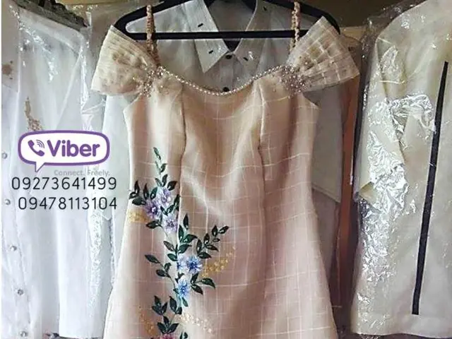 In this picture we can see a pamphlet with peach colored dress and other shirts in the background.